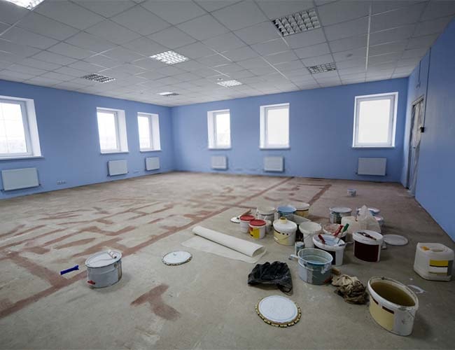 Office space with paint buckets and drop cloth being prepped for work | featured image for Services.